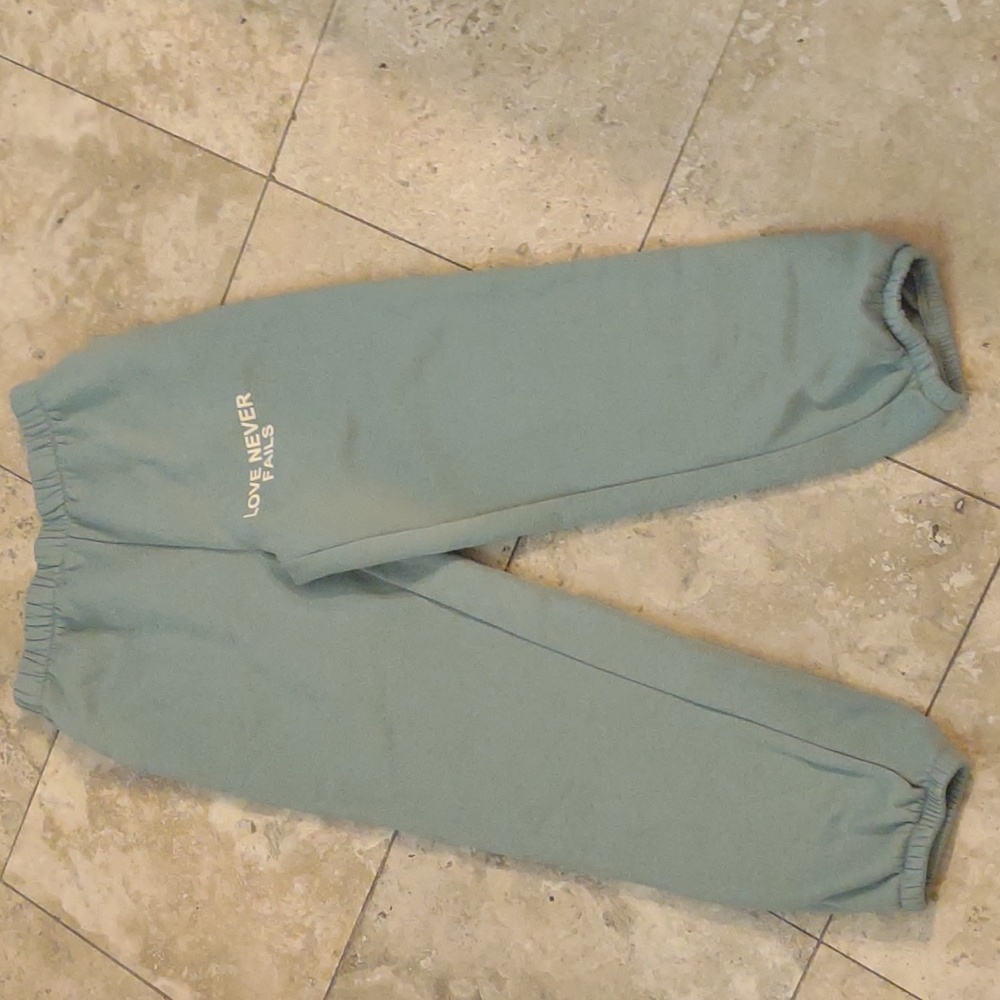 Large 'Love never fails' sweatpants